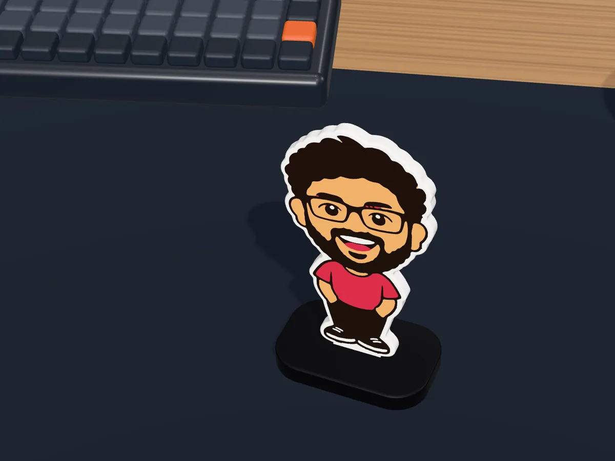 Mini-Me desk standee of a smiling man in a red t-shirt on a desk