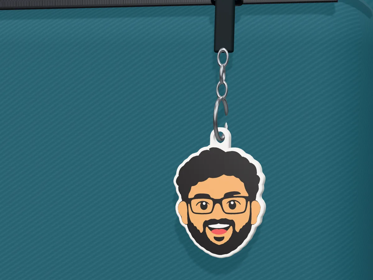 Mini-Me photo keychain of a smiling man with glasses hanging from a backpack
